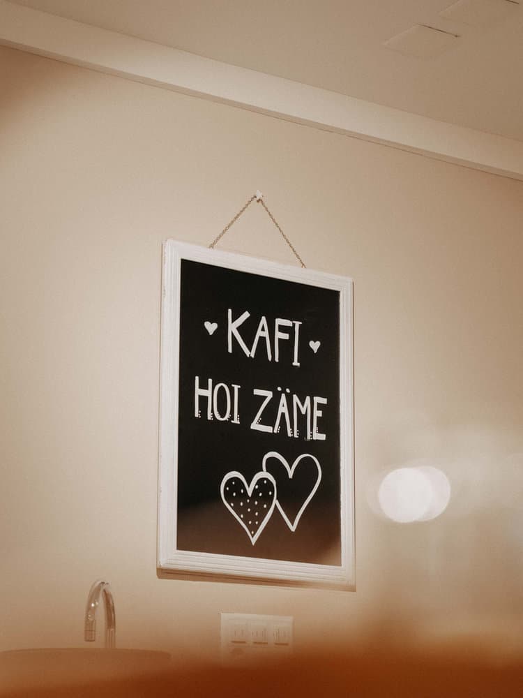 Kreidetafel mit der Aufschrift Kafi Hoi Zäme und zwei Herzen